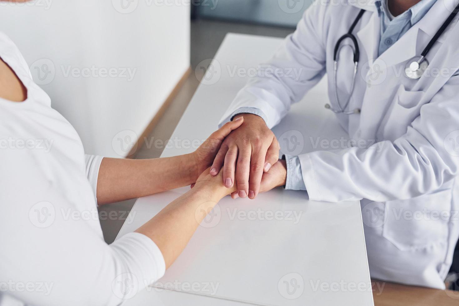 Professional help. Medic in white coat is in the clinic photo