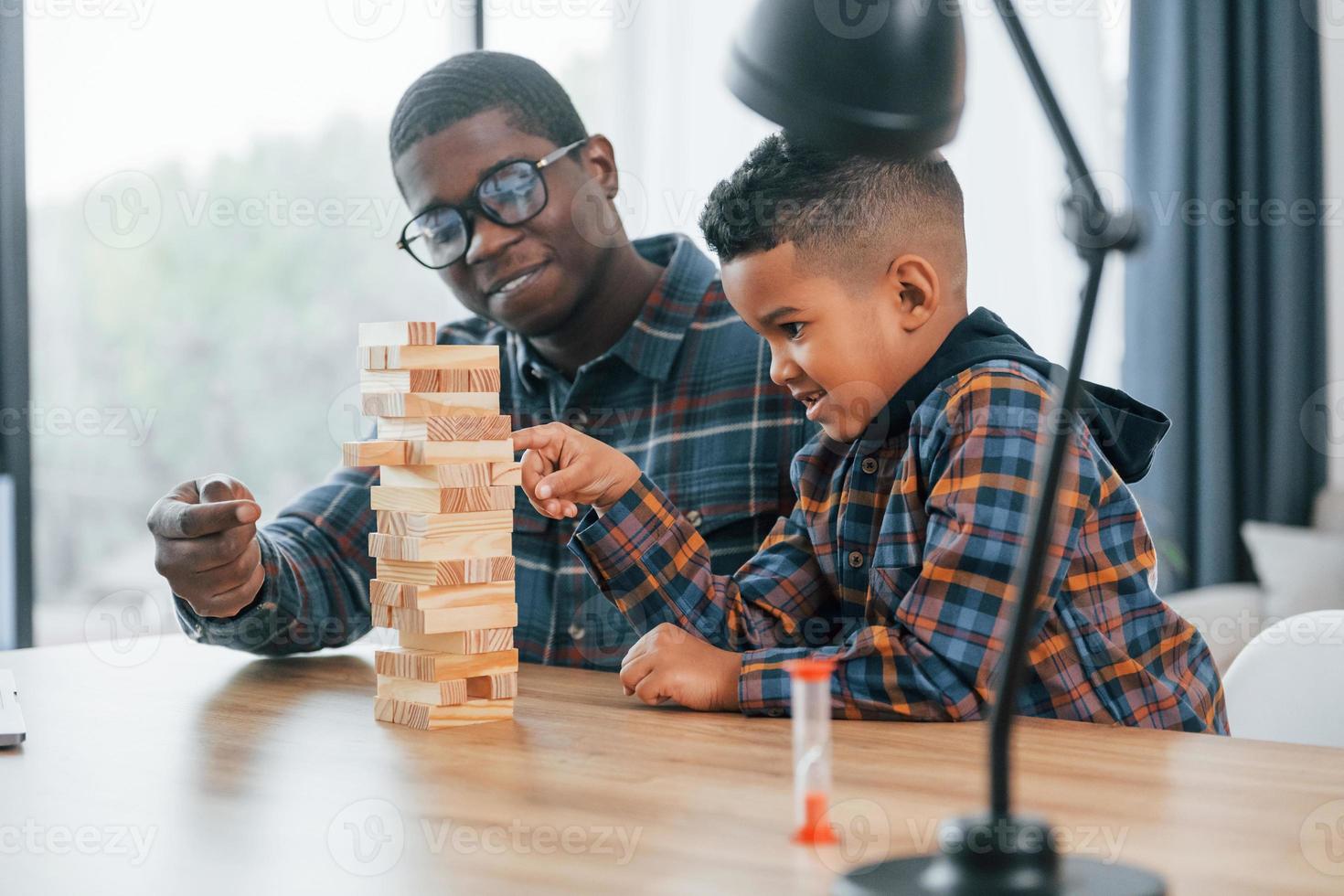 jugando juego de ladrillos. padre afroamericano con su hijo pequeño en casa foto