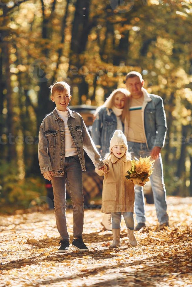 Front view. Happy family is in the park at autumn time together photo