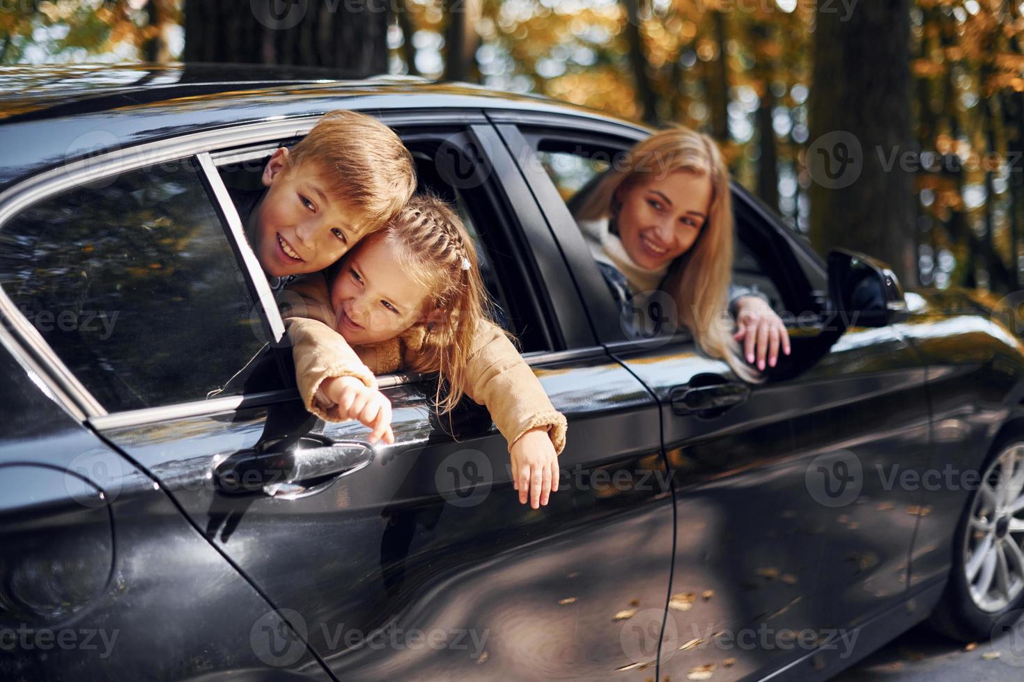 en el coche la familia feliz está en el parque en otoño juntos foto