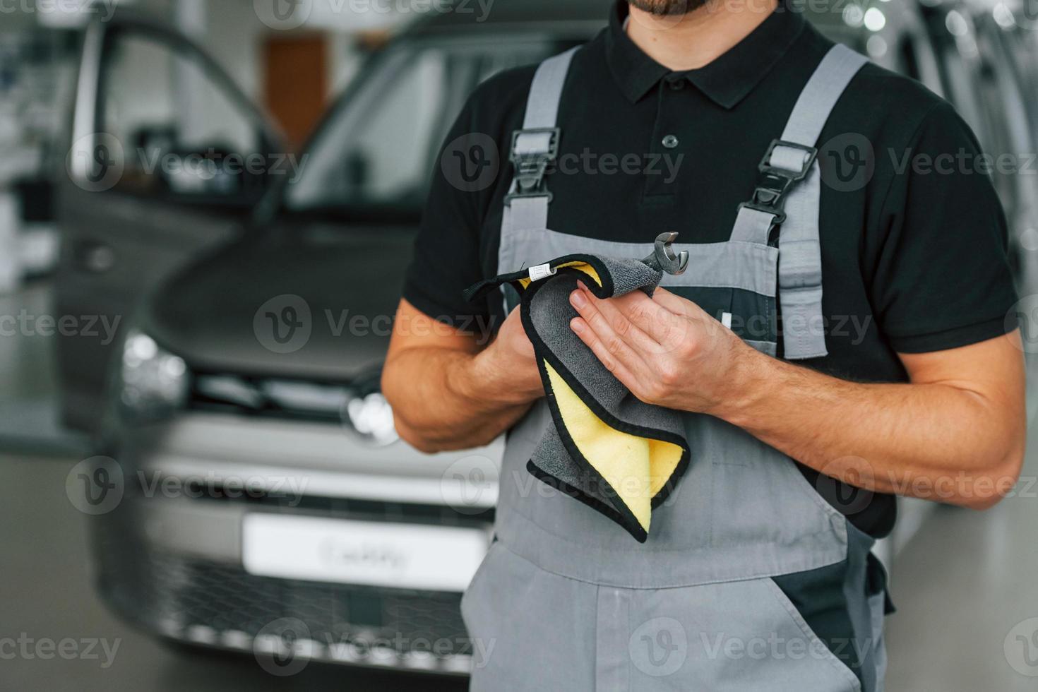 Man in uniform is working in the autosalon at daytime photo