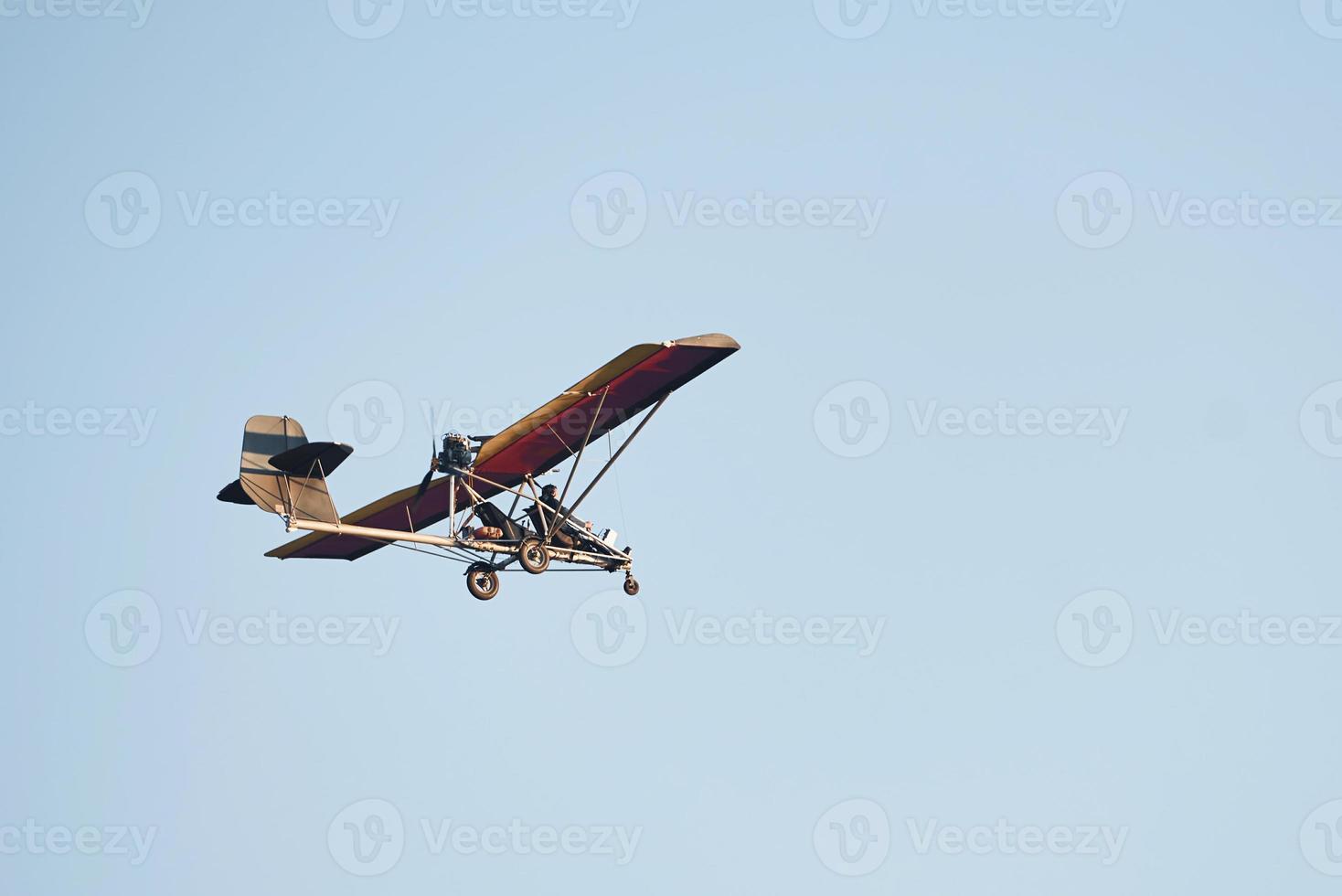 Plane flying high up in the cloudless sky at daytime. Male pilot photo