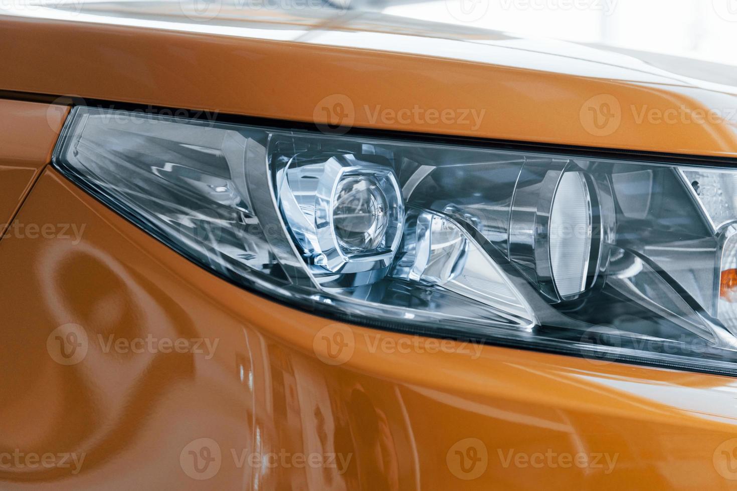Close up particle view of brand new car's front part. Parked indoors photo