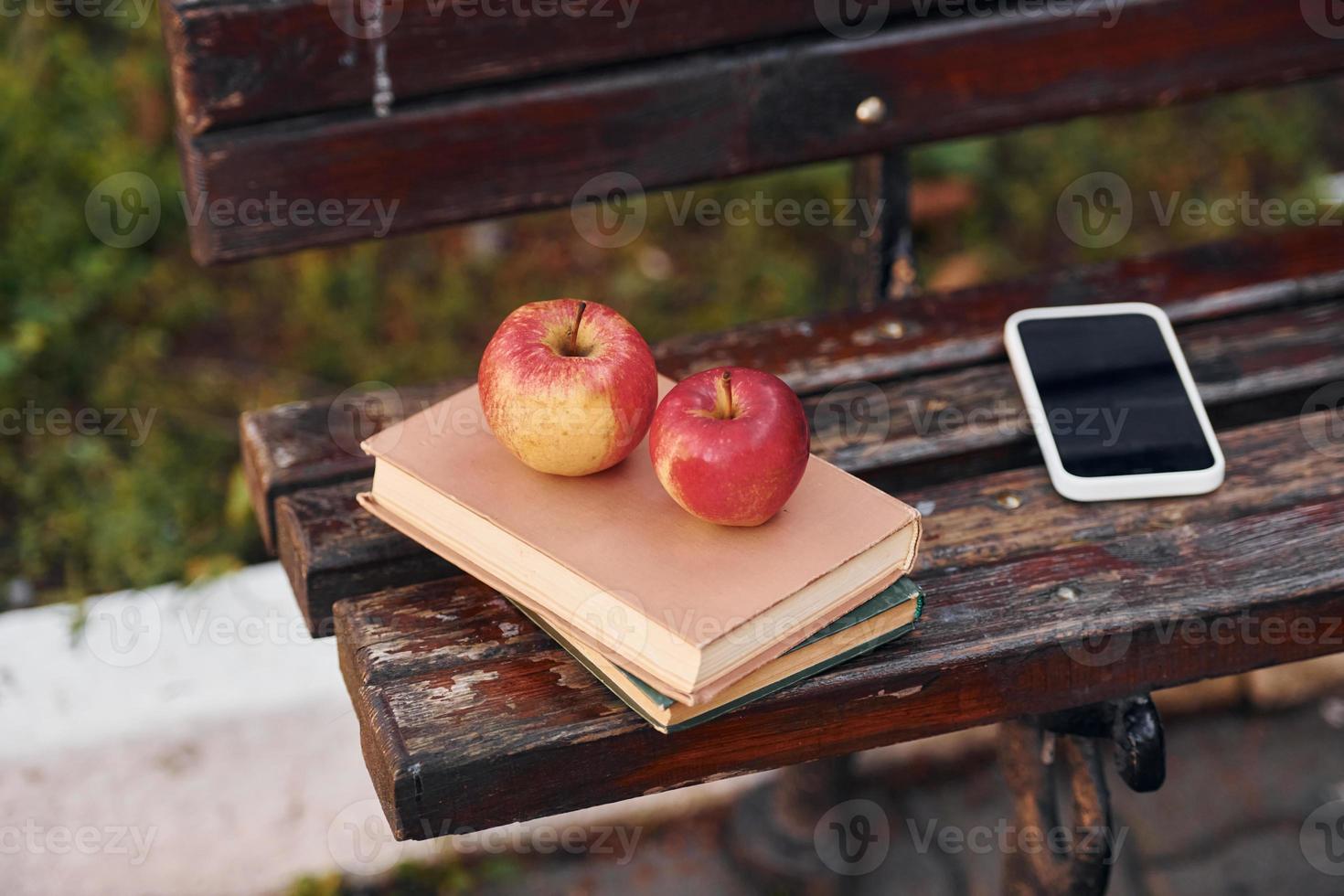 vista de cerca del sofá, y libros, manzanas y teléfono inteligente en él foto