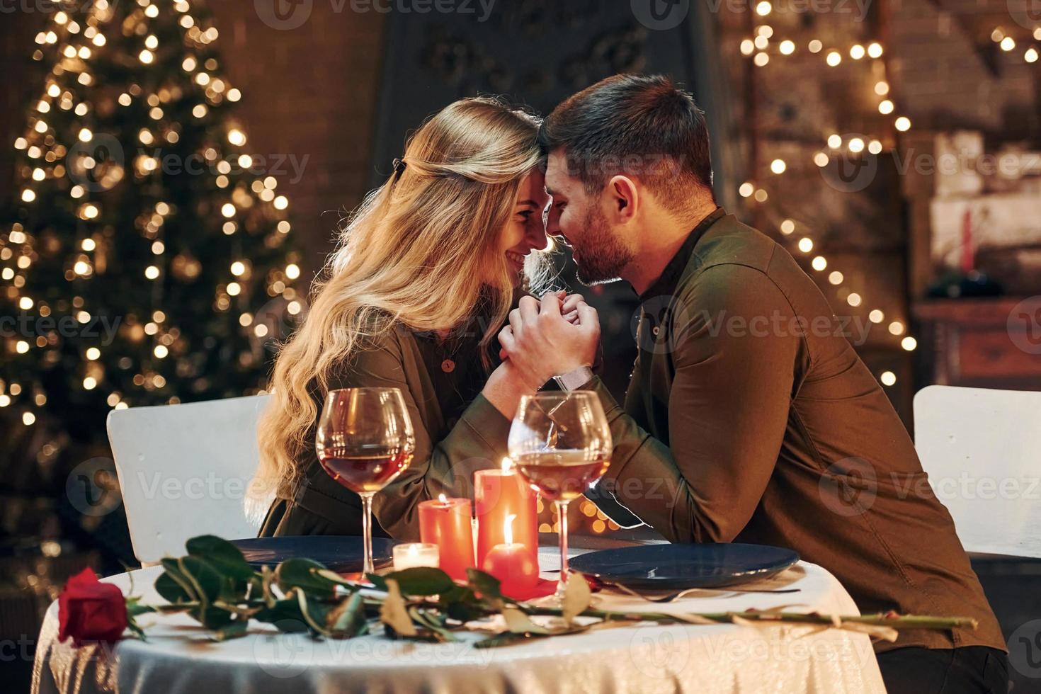 vista lateral. joven pareja encantadora tiene una cena romántica en el interior juntos foto