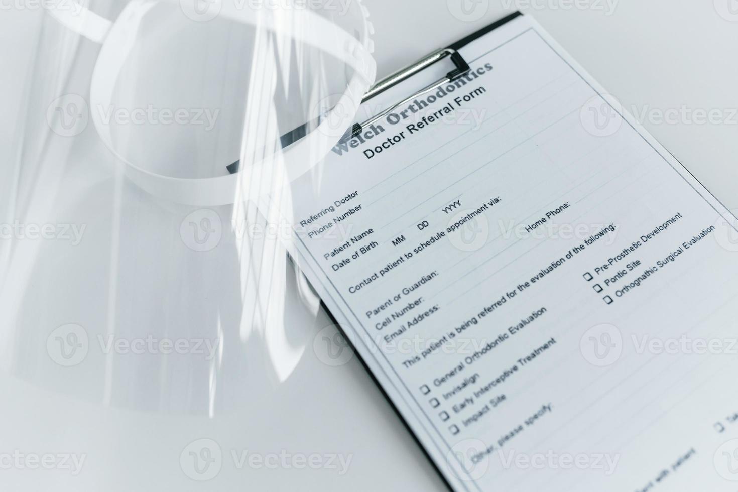 Close up view of protective mask and medical agreement that is on the white table photo