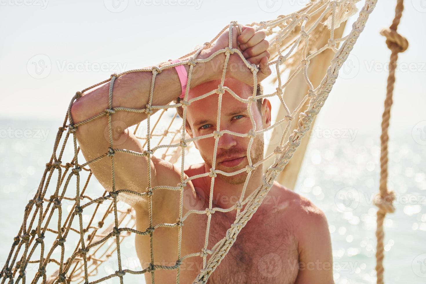 Warm weather. Young european man have vacation and enjoying free time on the beach of sea photo