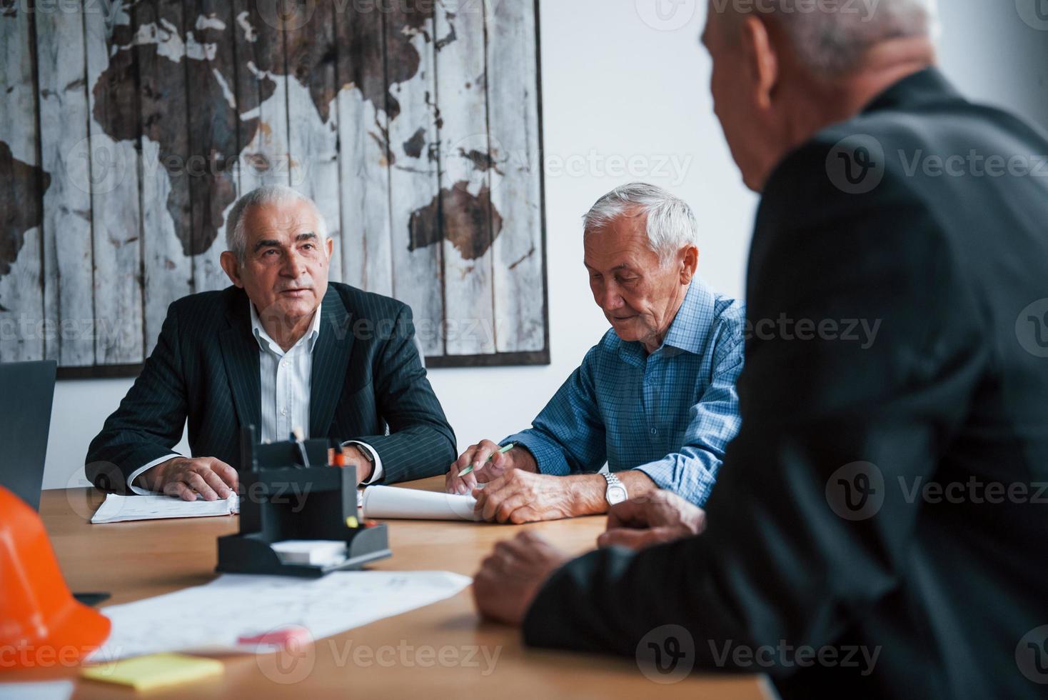 Aged team of elderly businessman architects have a meeting in the office photo