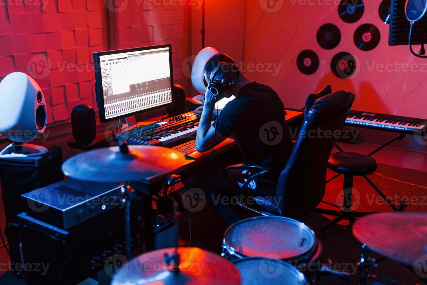 joven ingeniero de sonido trabajando y mezclando música en interiores en el estudio foto