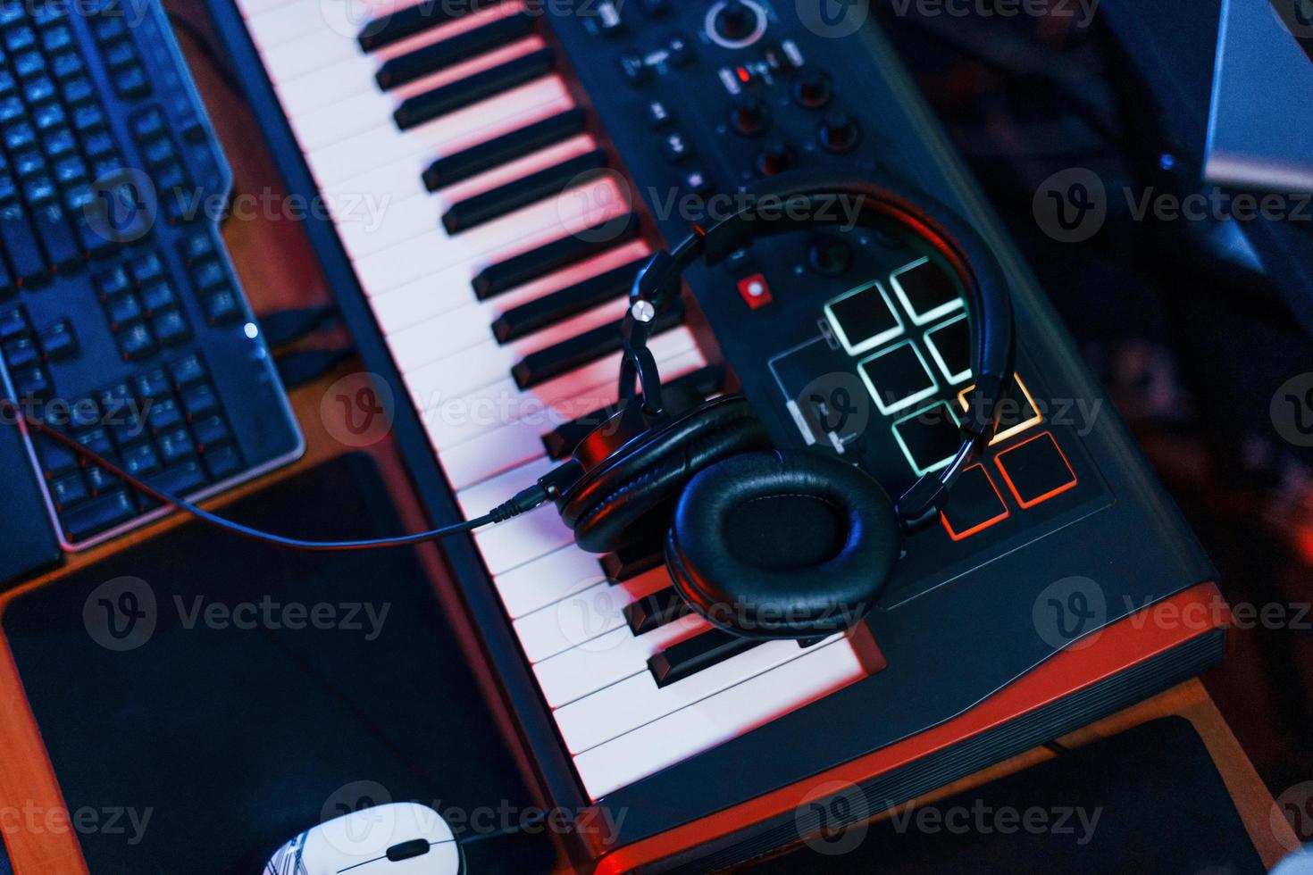 Close up view of headphones that lying down on the keyboard in the studio photo