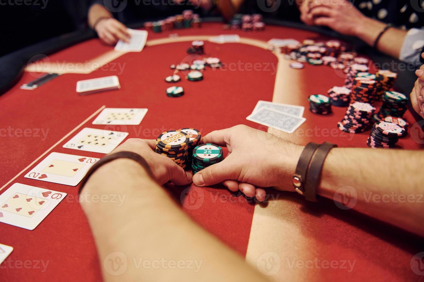 Group of elegant young people that playing poker in casino together photo