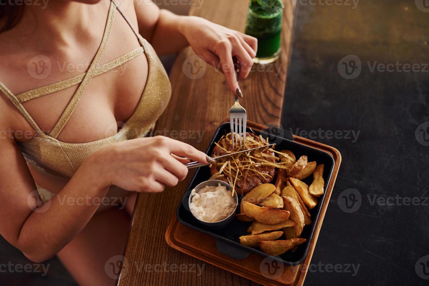 vista de cerca de la mujer que come comida rápida en el interior de la cafetería foto