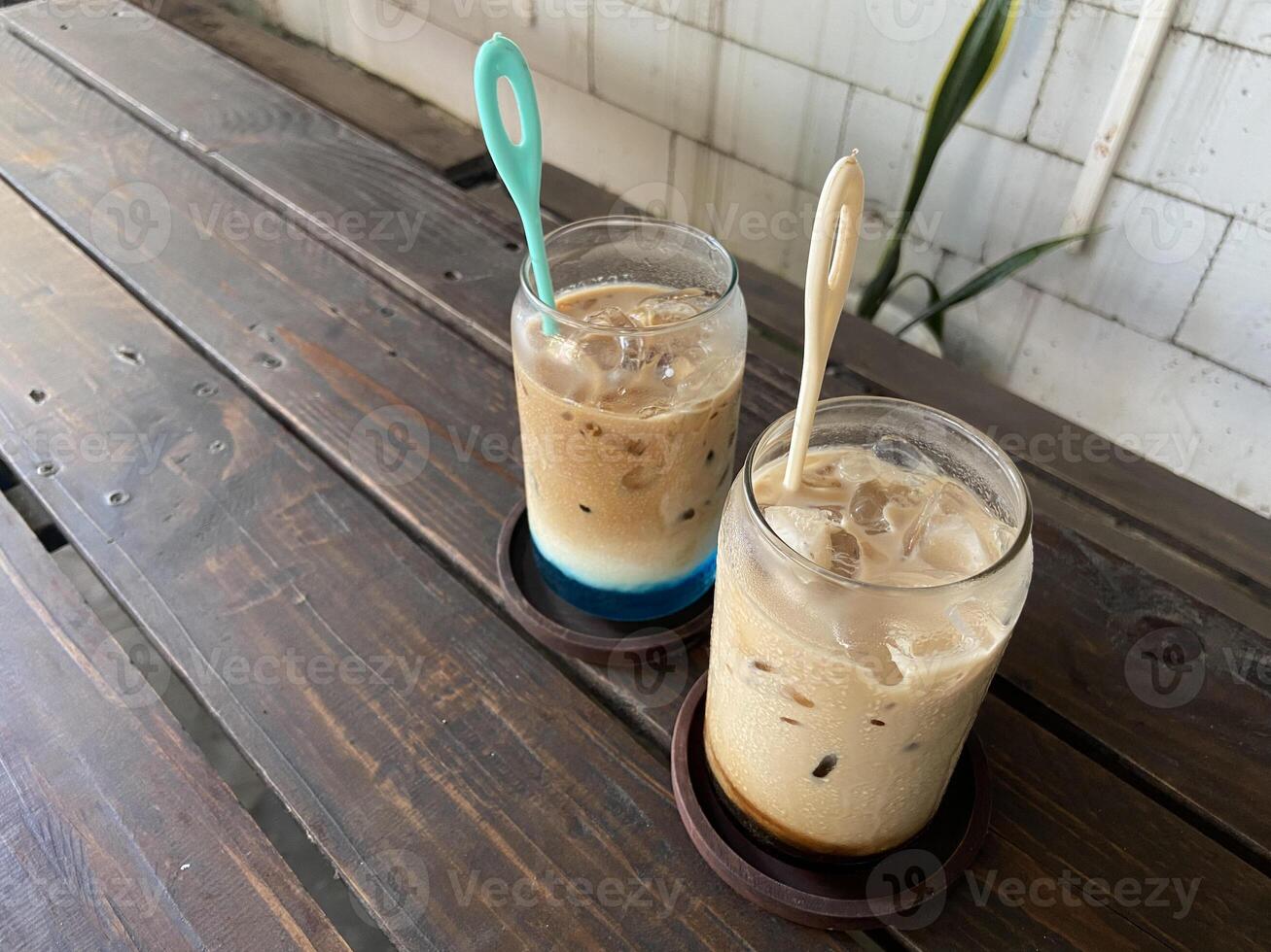 Glass of a iced coffee with cream milk. Cold brew coffee drink with ice. Early morning sun light. Copy space. photo