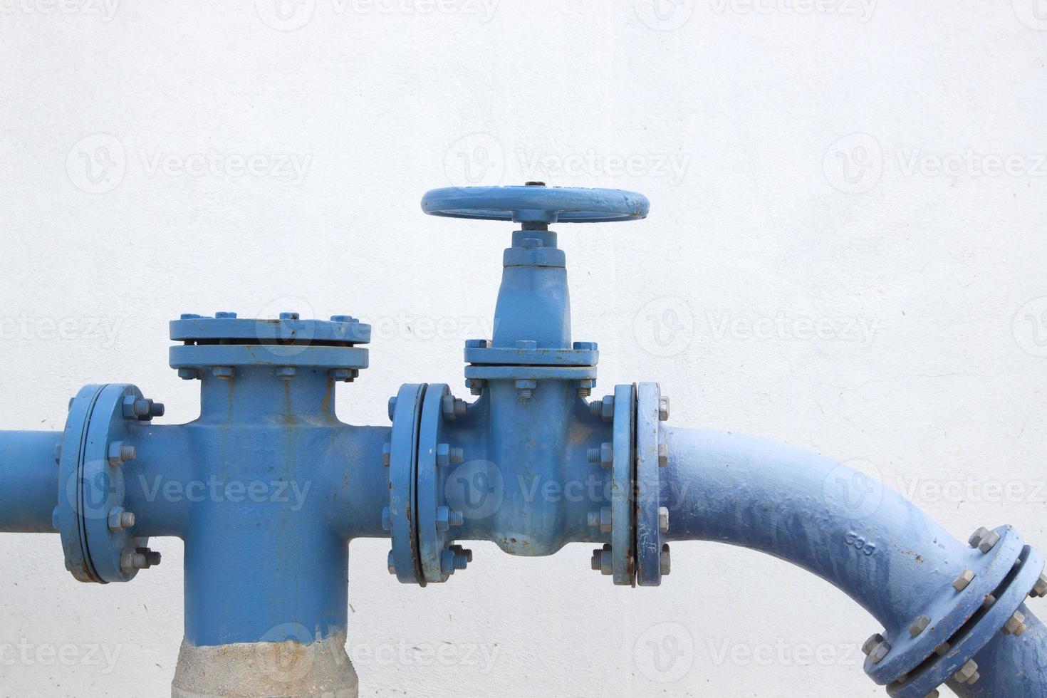 Large water supply valve with a white background of the cement wall photo