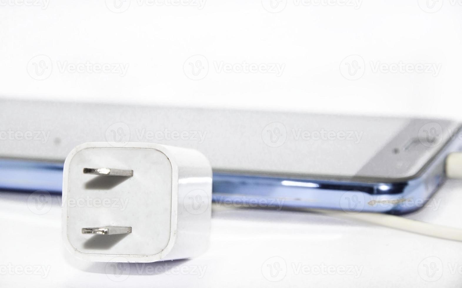 Mobile phone charging cable White-black smartphone on a white background taken in a studio in my house with lights and flash for clarity. photo