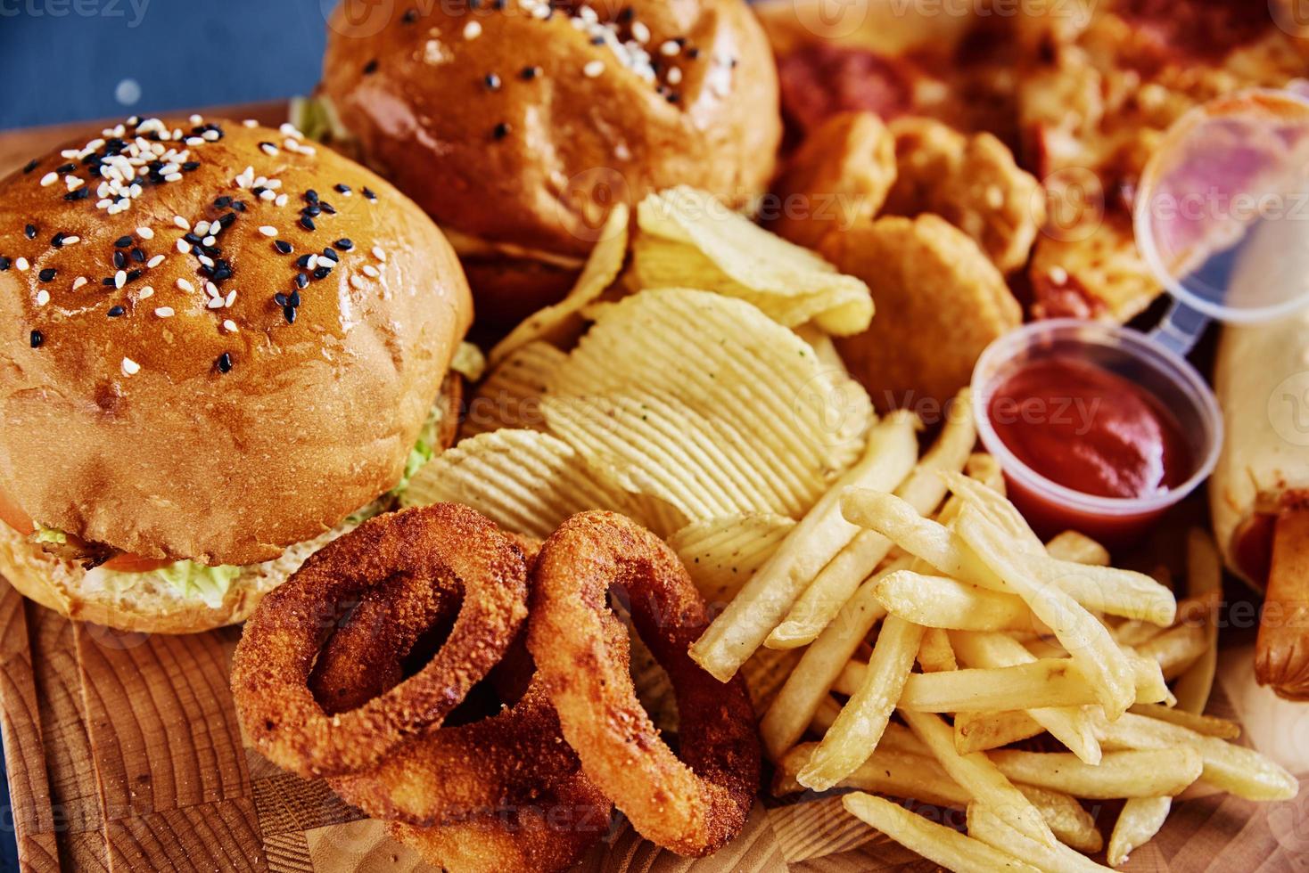 Unhealthy and junk food. Different types of fast food on the table, closeup photo