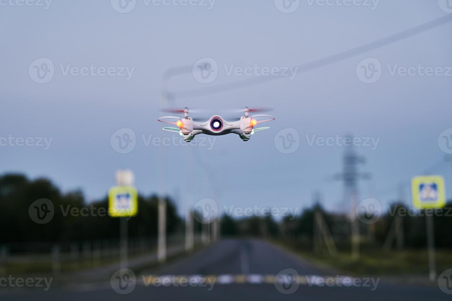 Toy drone quad copter against sunset sky photo
