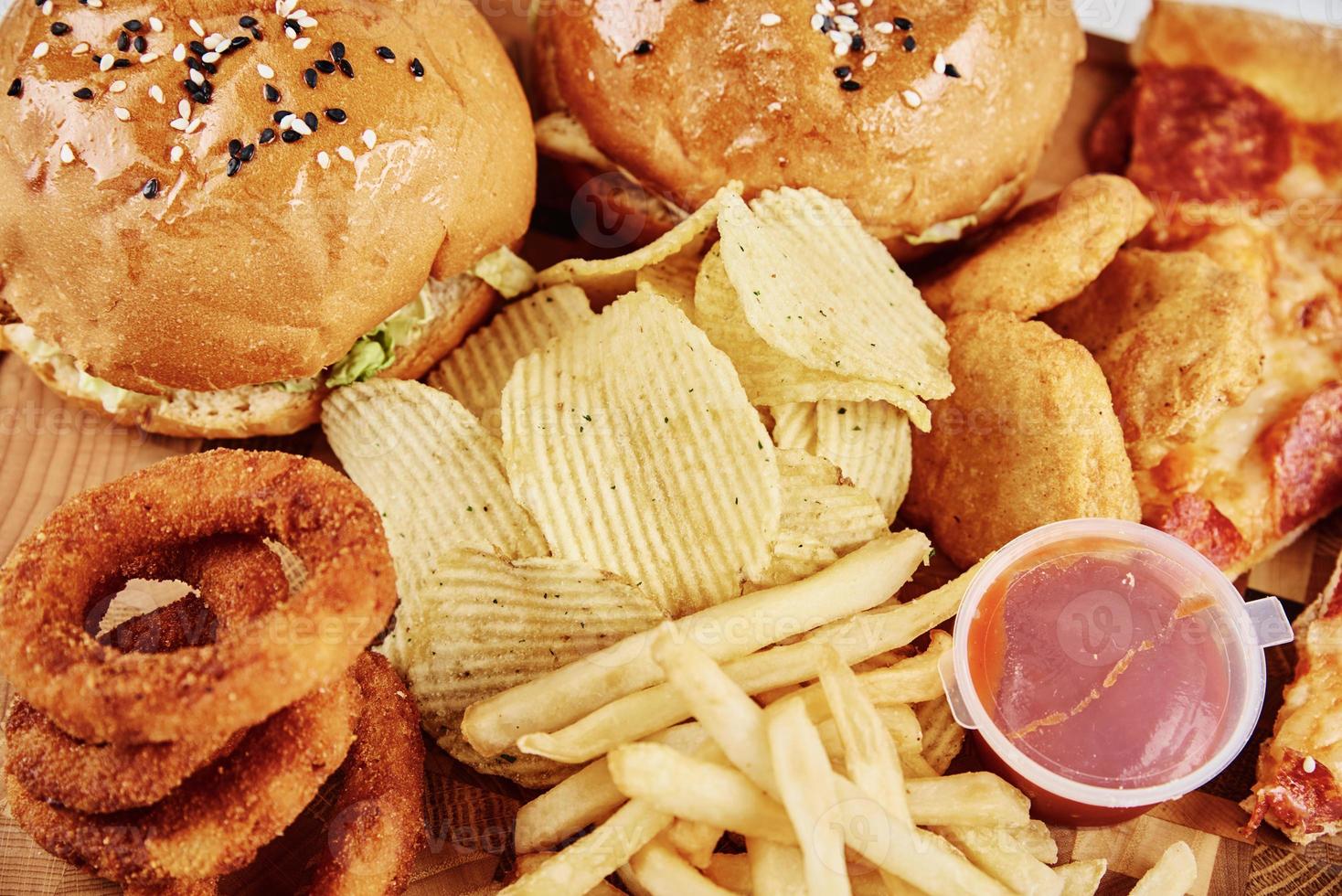 Unhealthy and junk food. Different types of fast food on the table, closeup photo