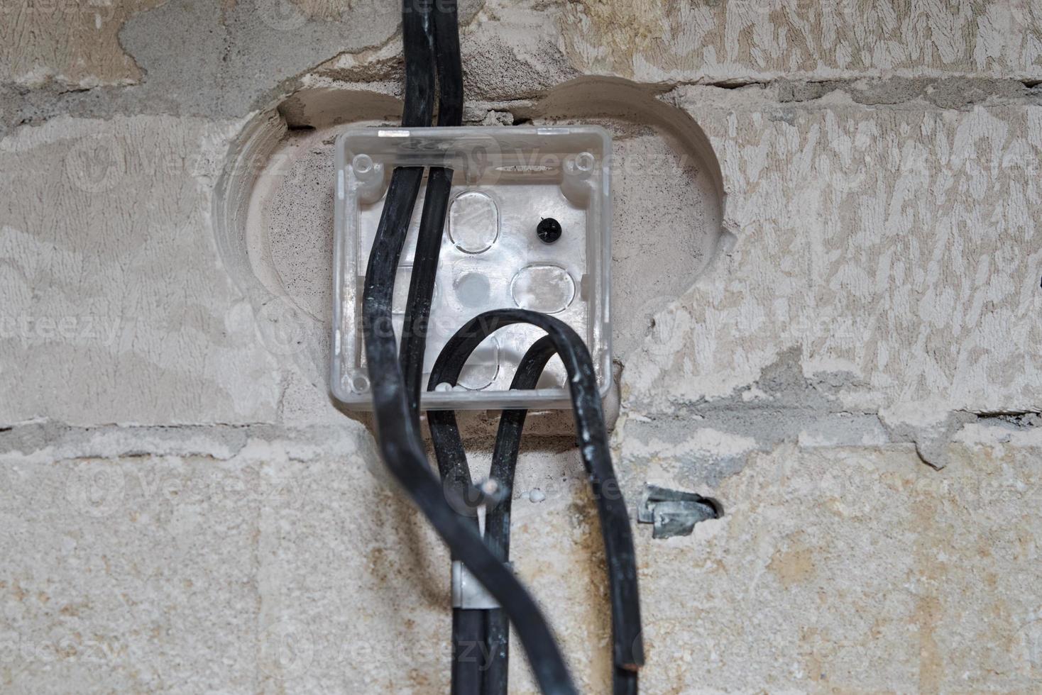 enchufe para cableado en una pared de hormigón. concepto de renovación foto