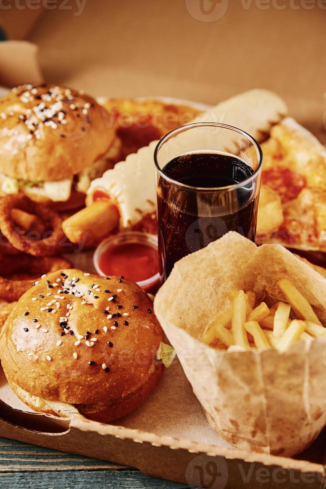 Unhealthy and junk food. Different types of fast food on the table, closeup photo