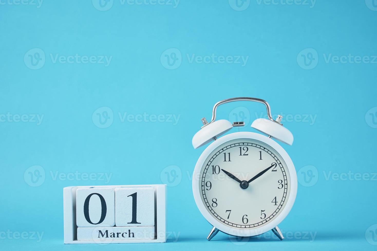 White retro alarm clock with bells and wooden calendar blocks photo