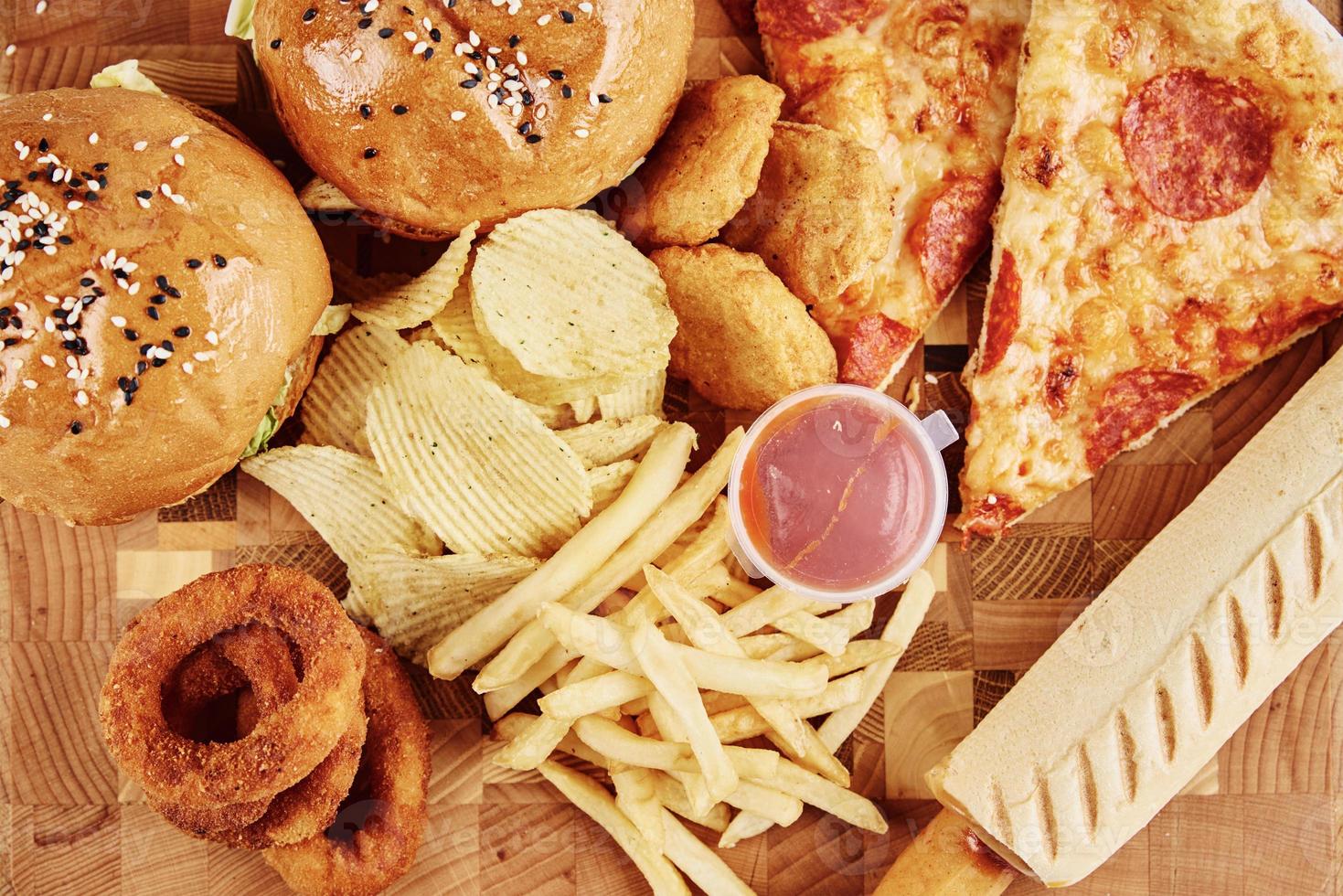 Unhealthy and junk food. Different types of fast food on the table, closeup photo