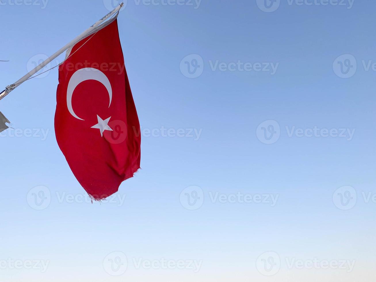 Large flag of Republic of Turkey on sky background photo