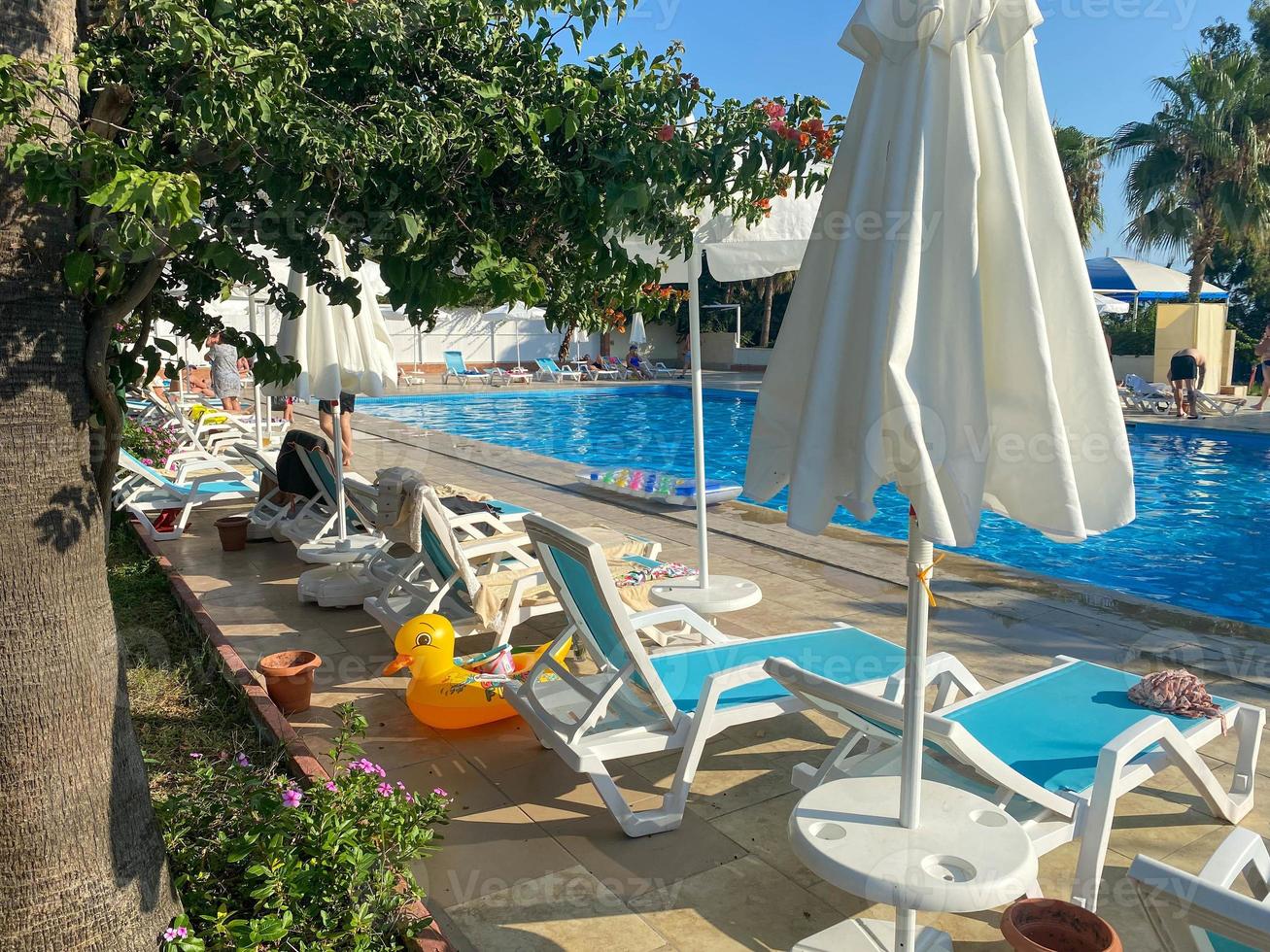 Sun loungers for relaxing and sunbathing with sun umbrellas near the pool for swimming and chilling in the hotel on vacation in a paradise warm eastern tropical country resort photo