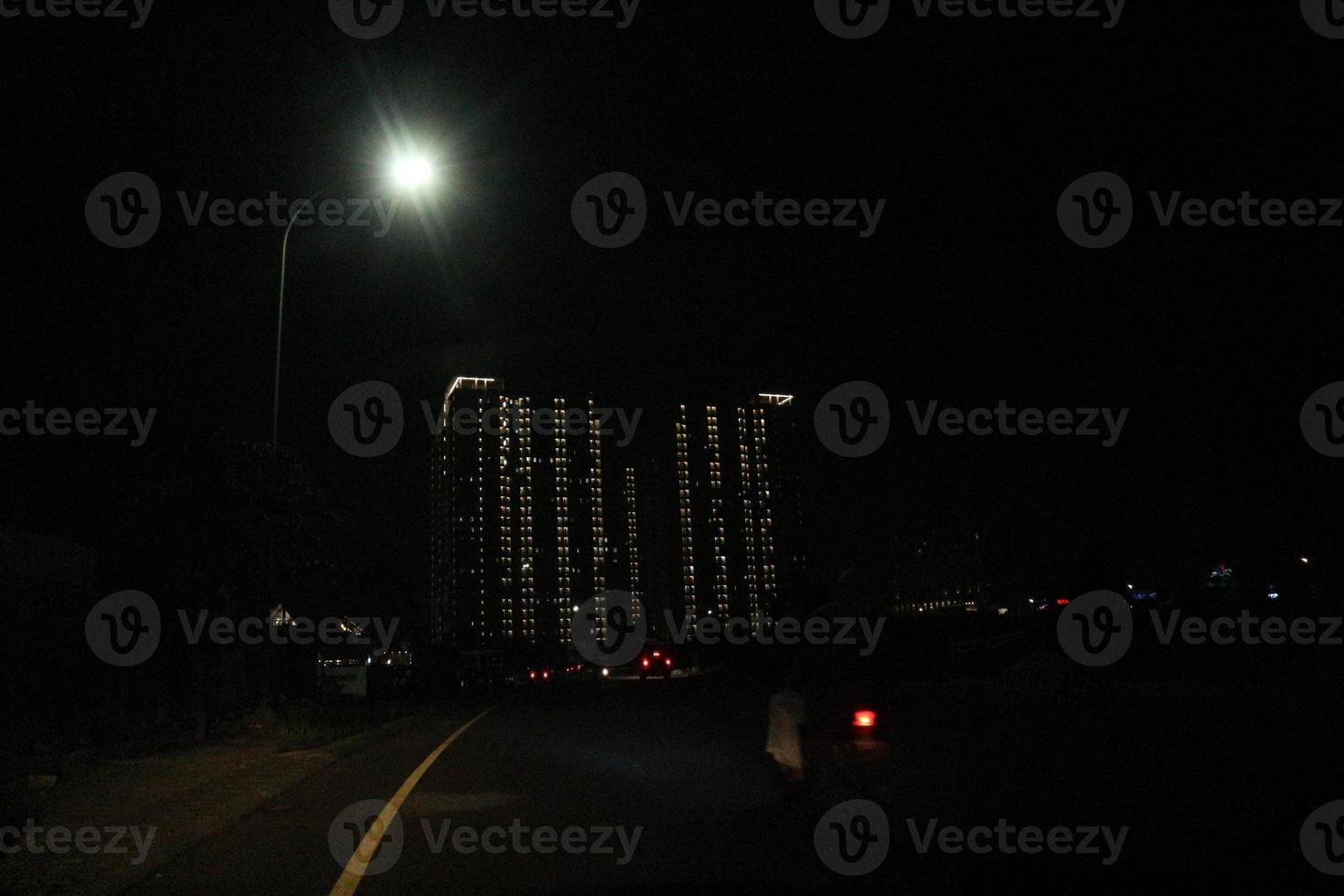 condiciones en la noche en las que se pueden ver rayos de luz perfectamente ordenados provenientes de un apartamento foto