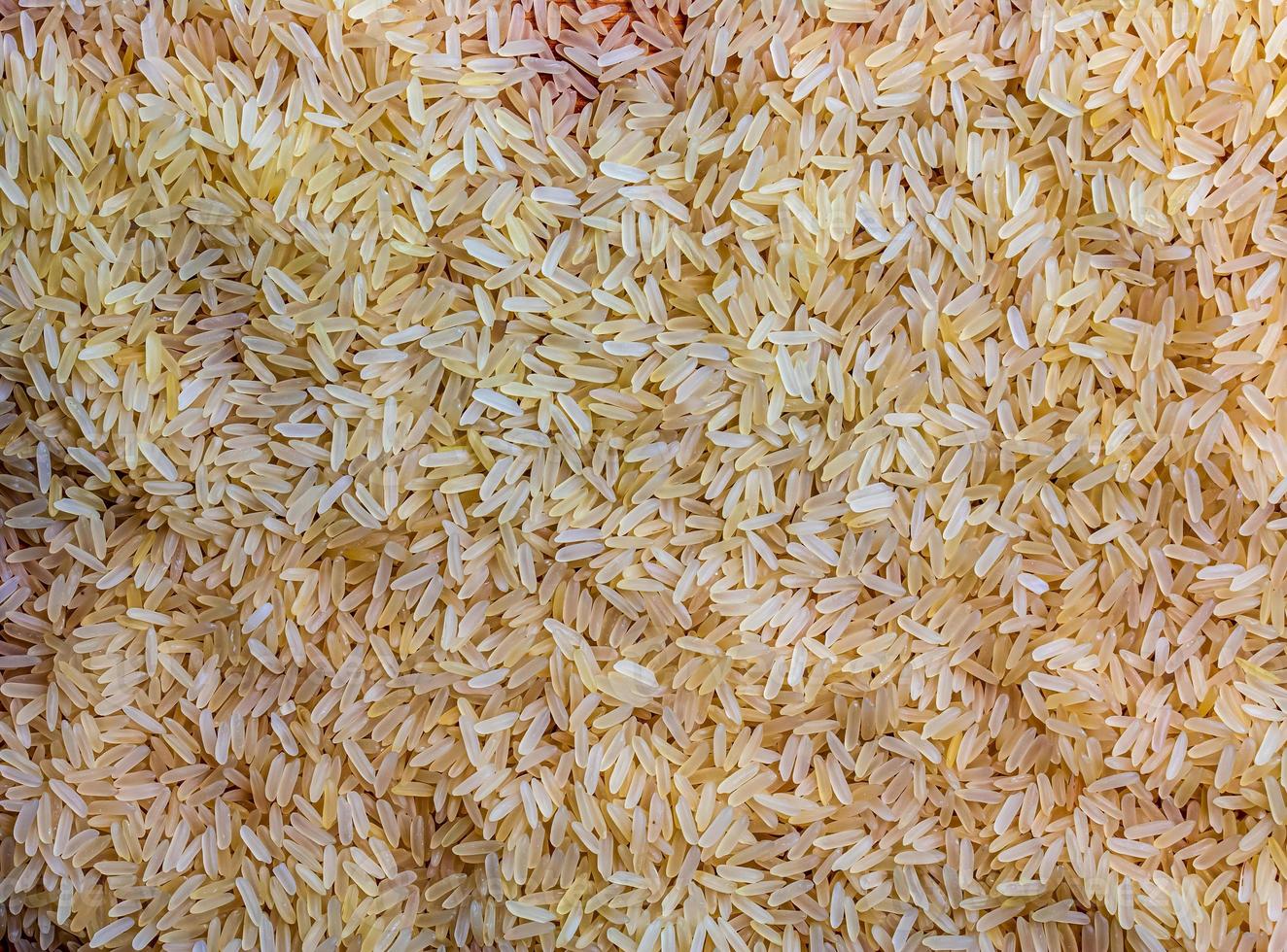 Background of long grain parboiled uncooked rice. Rice groats as background and texture. photo