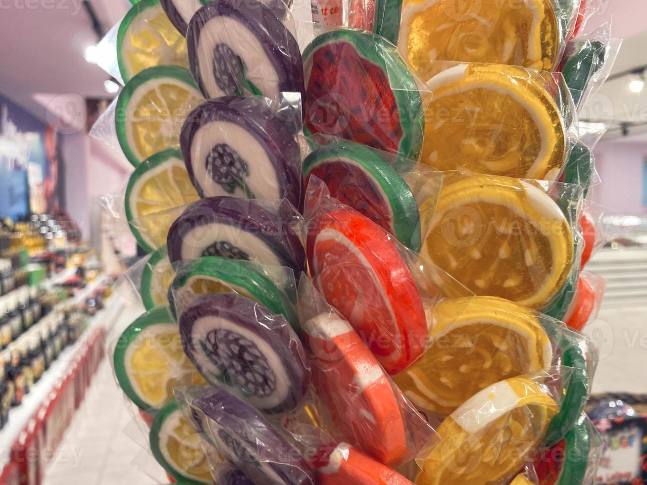 Colorful wrapped lollipops on display, hand made candy, small and big lollipops. photo