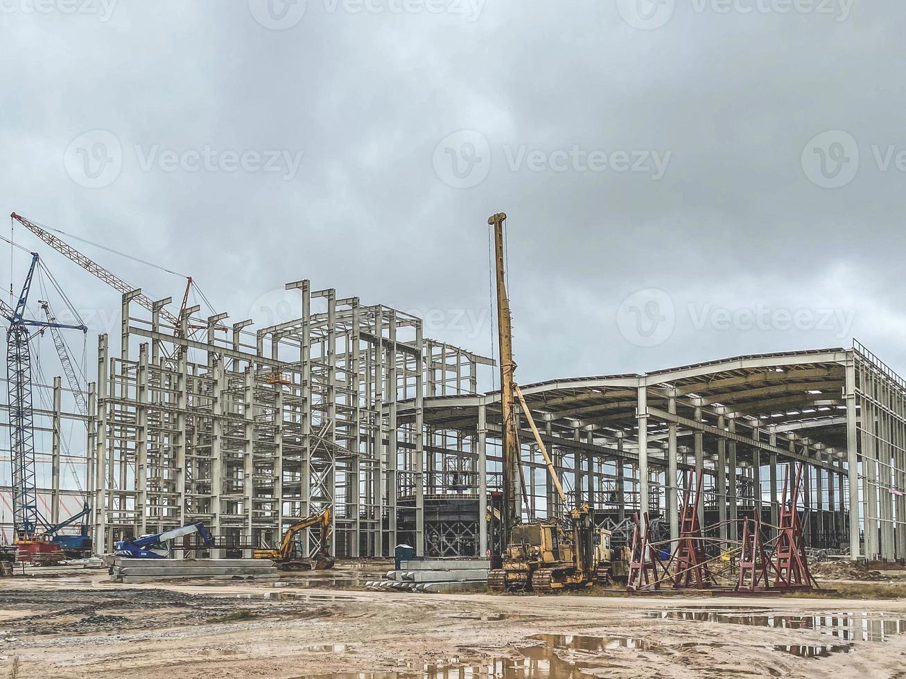 construction of a new complex at the plant. metal structures for the construction of the foundation. yellow crane carries heavy material through the air photo
