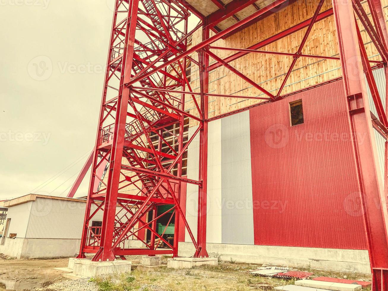 construction site. tall, metal, red faucet next to the warehouse. metal gate, factory entrance photo