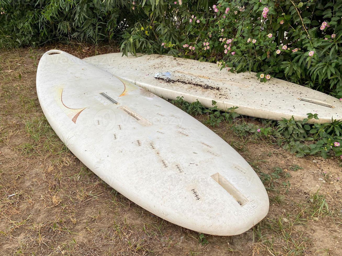 dos tablas de surf blancas yacen en el suelo en el paradisíaco país tropical del este del resort. foto