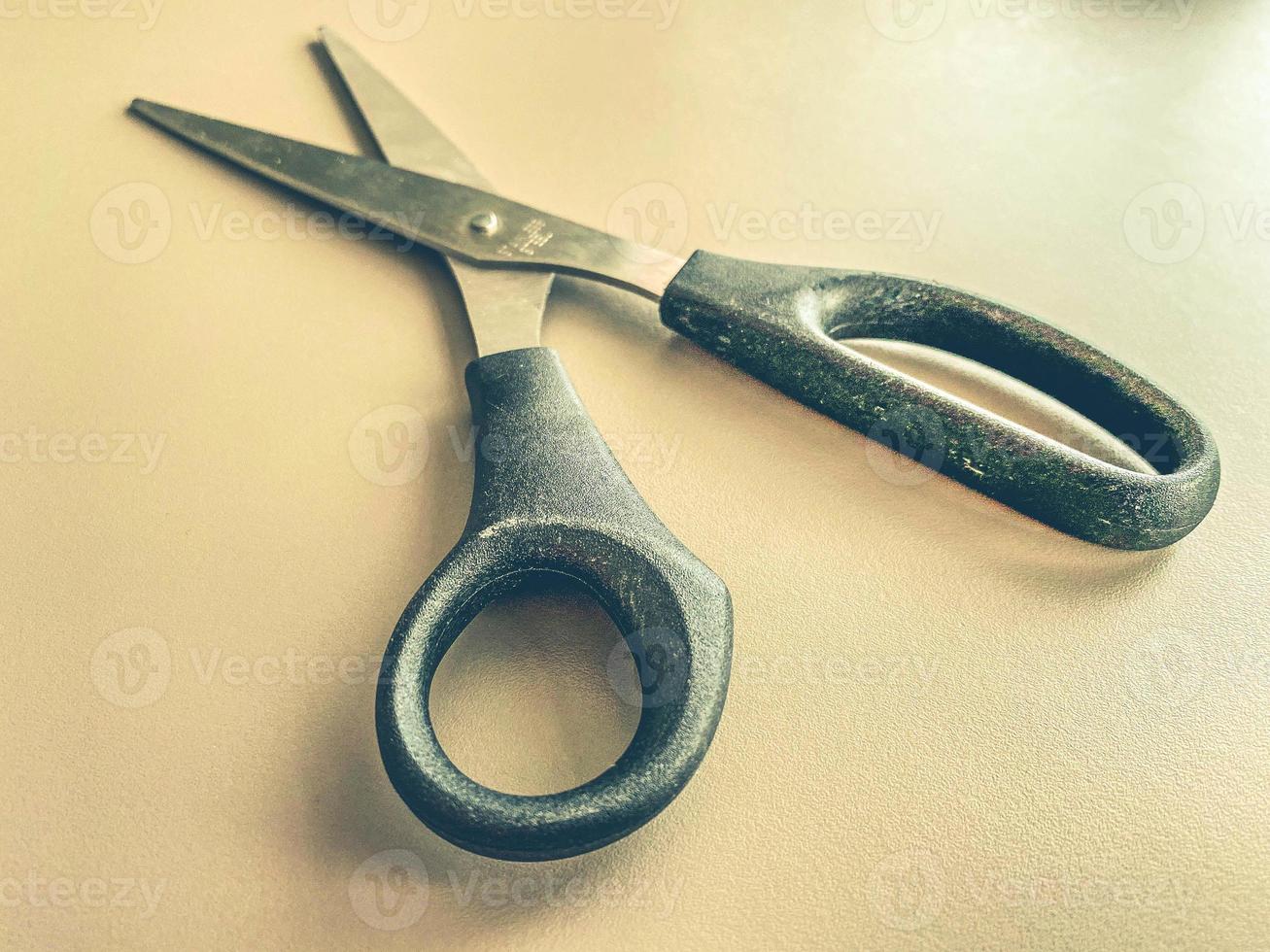 papelería en la mesa de la oficina. tijeras de metal con mango negro. corte de papel, herramienta para el trabajo. tijeras sobre un fondo blanco mate foto