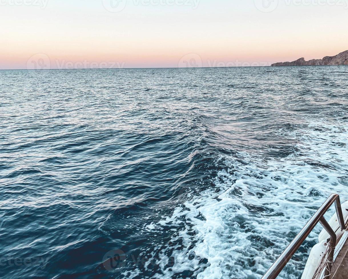 walk on the open sea. blue waves of the sea on the background of the sunset. the yacht is equipped with metal sides for the safety of tourists. holidays in hot countries photo