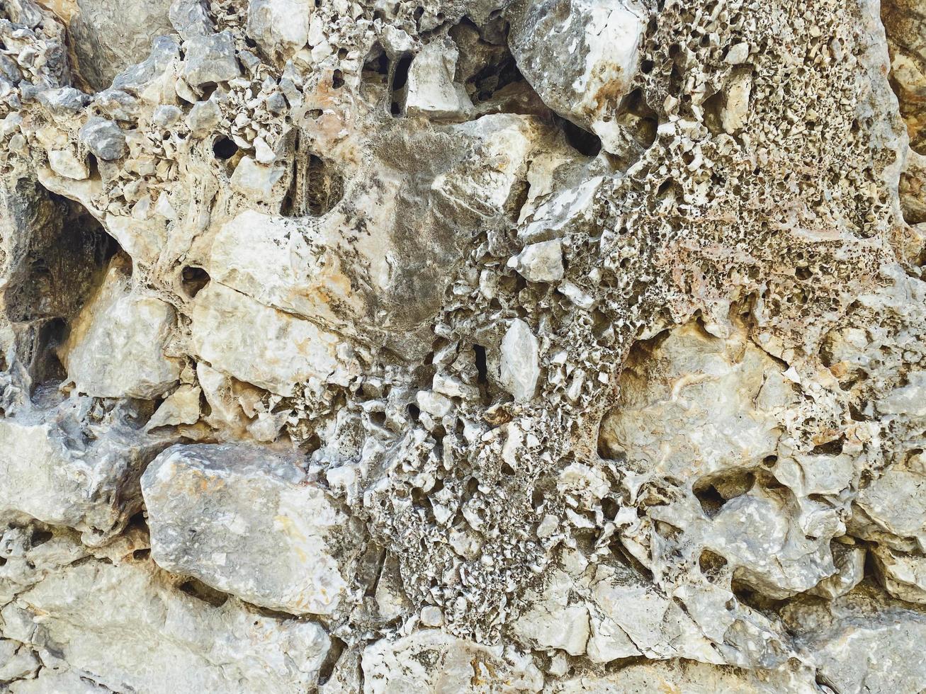 rock formation on the sea. a stone made of sand, a large boulder lies on the beach. texture, natural background. volumetric background of gray stone photo