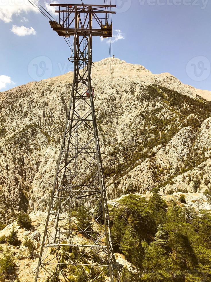 mountains in a hot, tropical country against a blue sky. green plants grow on the mountains. cable car on the background of the power line photo