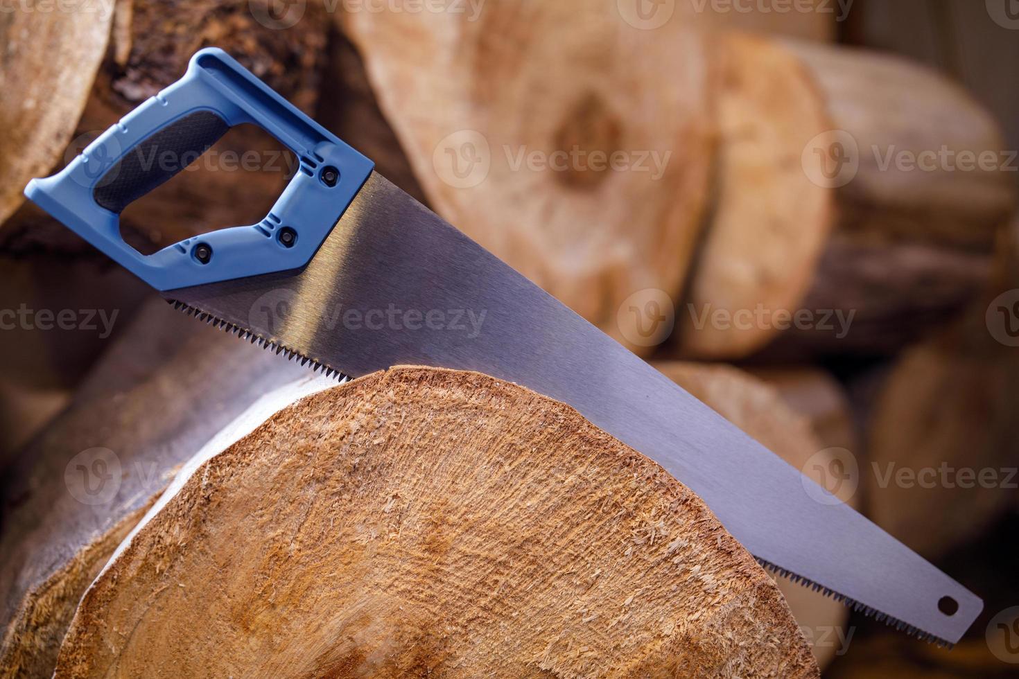 A hand hacksaw on a tree saws a log. photo