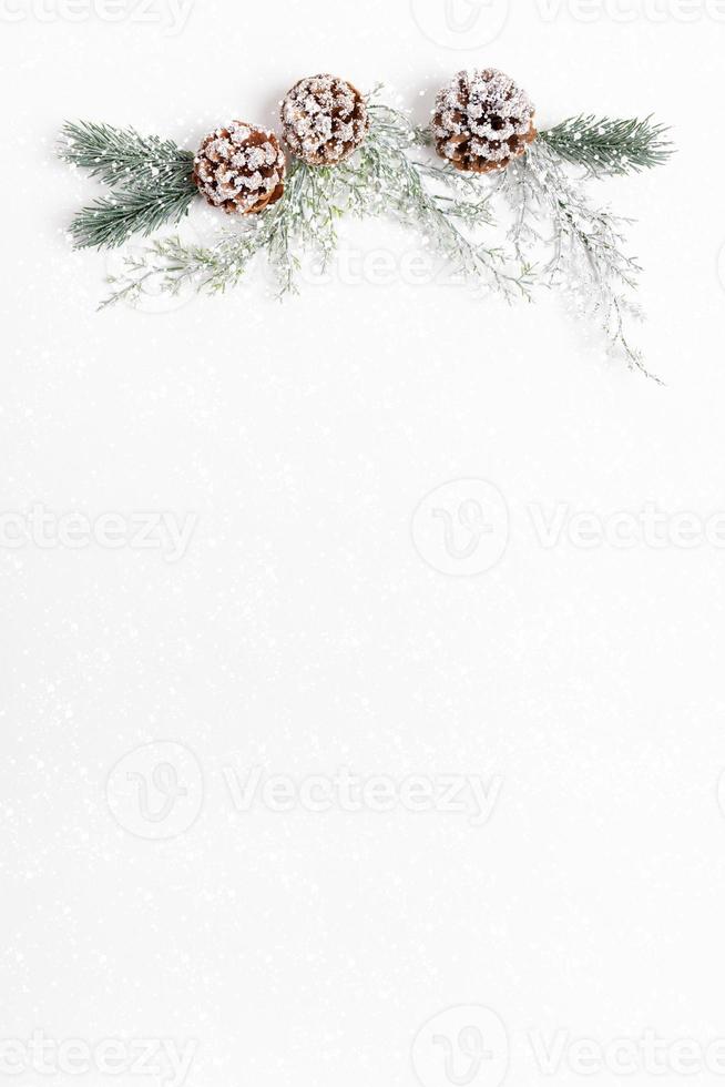 Xmas festive background with reusable decor made of tree twigs and pine cones on top of empty white sheet with snow. photo