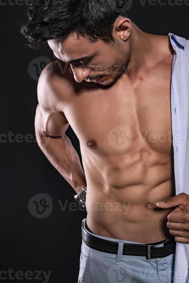 Handsome Arab male model with perfect body posing in studio. Portrait of a  athletic male model posing on dark background in the studio. Fashion  concept. 15473512 Stock Photo at Vecteezy