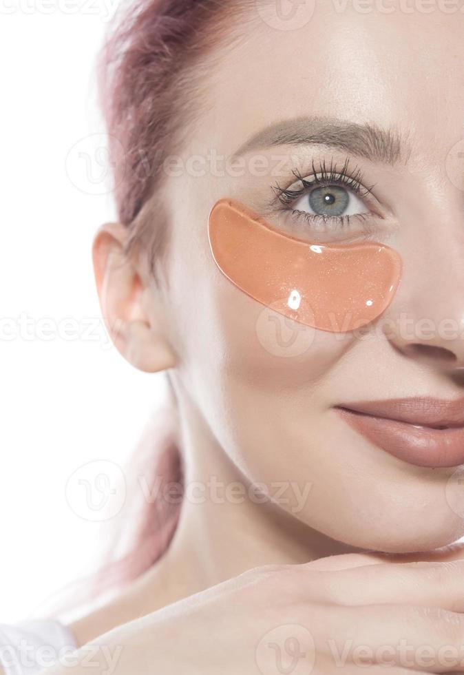 woman with cosmetic patches moisturizing on skin under eyes. photo