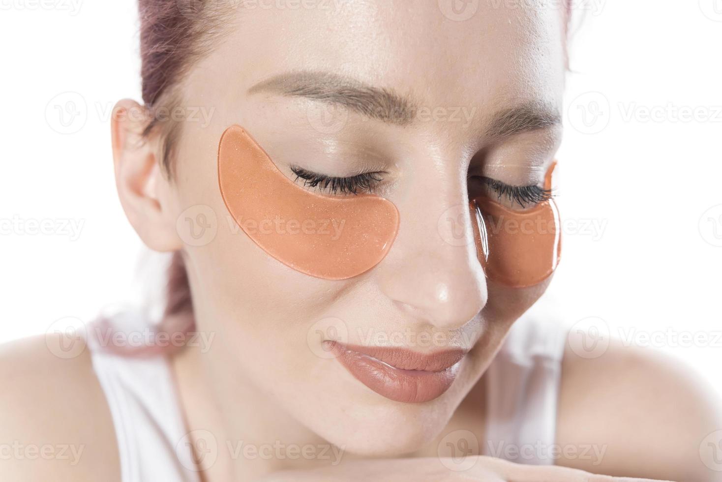 woman with cosmetic patches moisturizing on skin under eyes. photo
