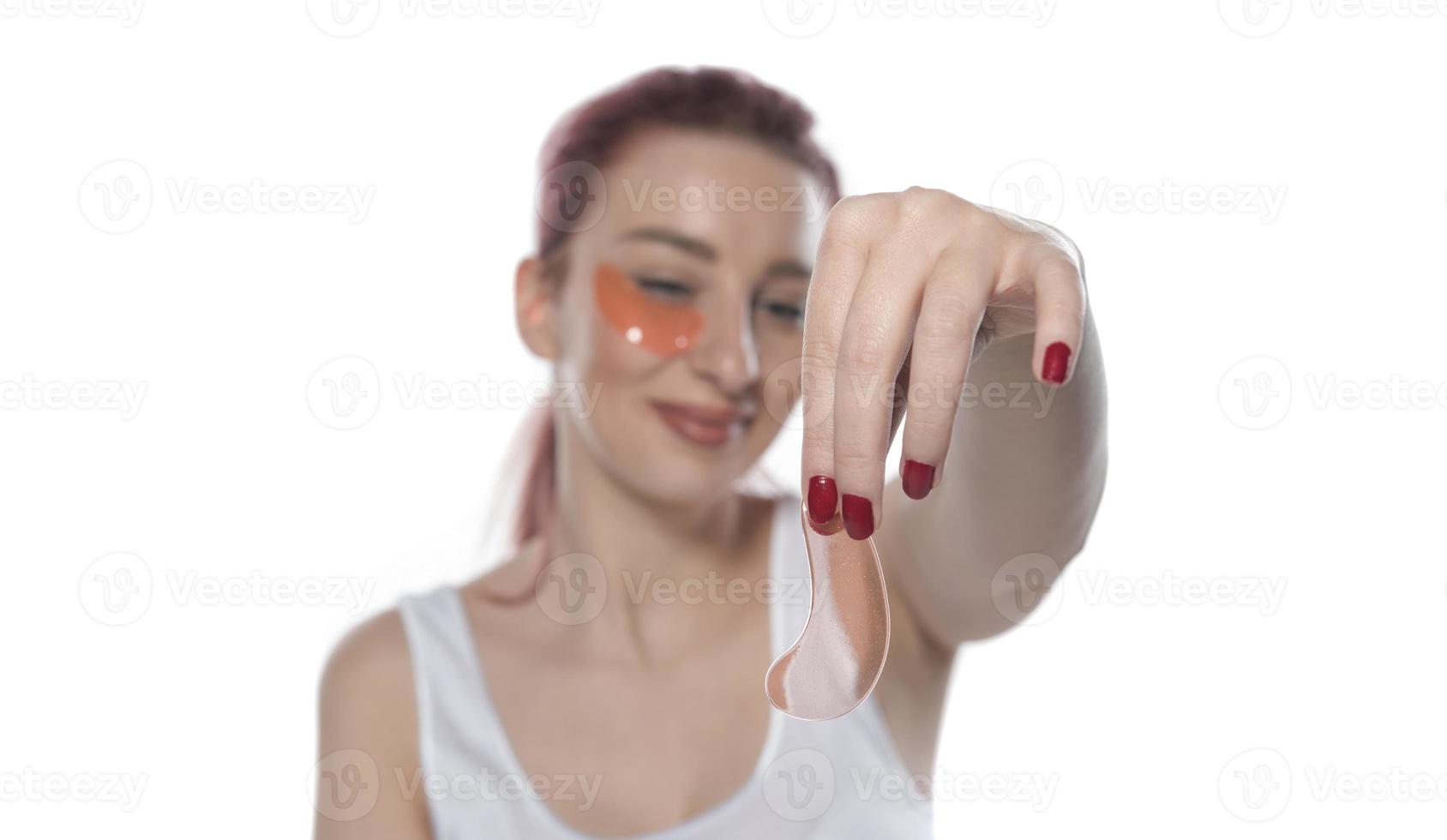 woman with cosmetic patches moisturizing on skin under eyes. photo