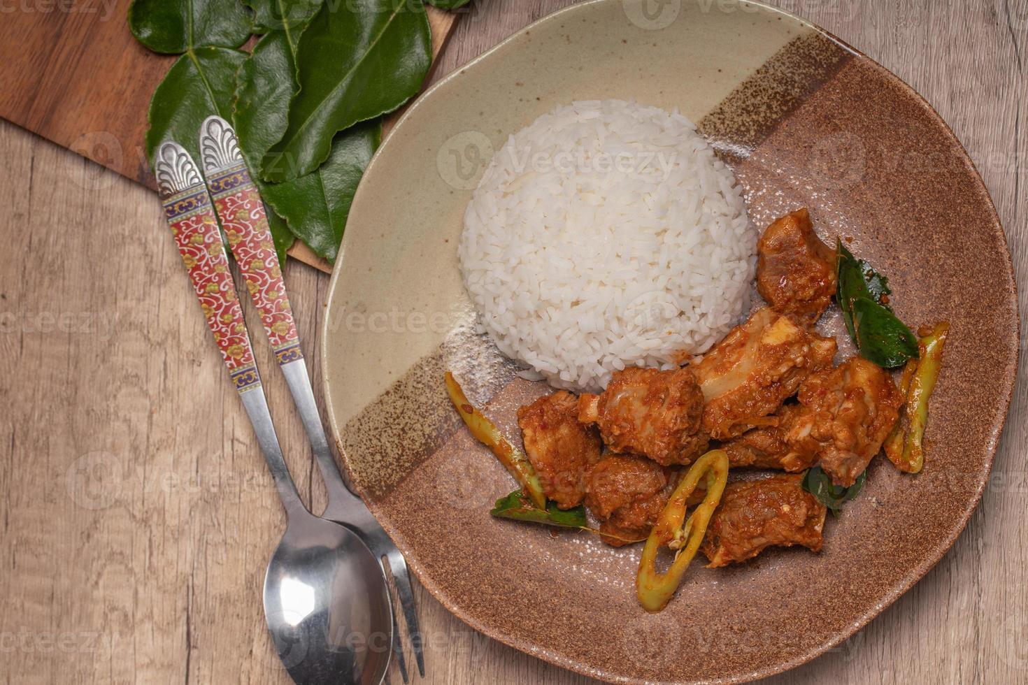 Stir-fried pork ribs with curry paste and steamed rice photo