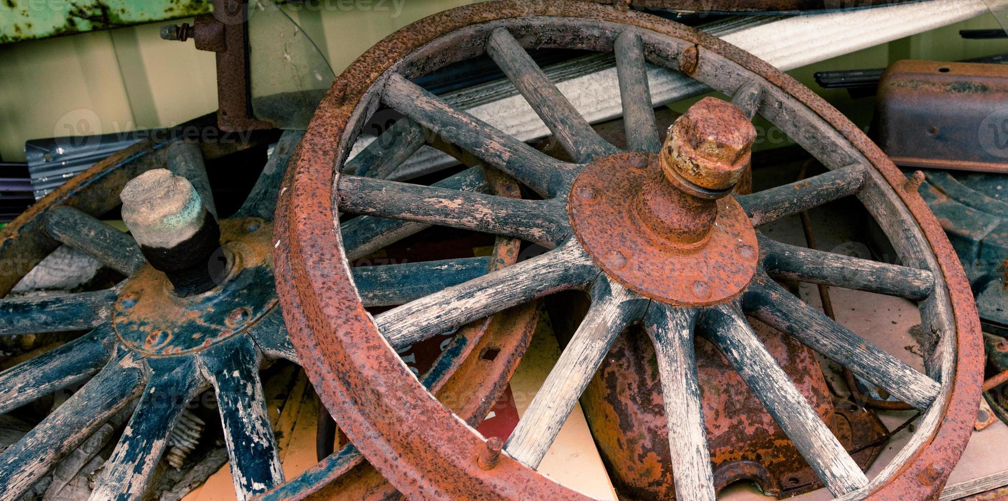 Wooden spoked wheels laying in a pile photo