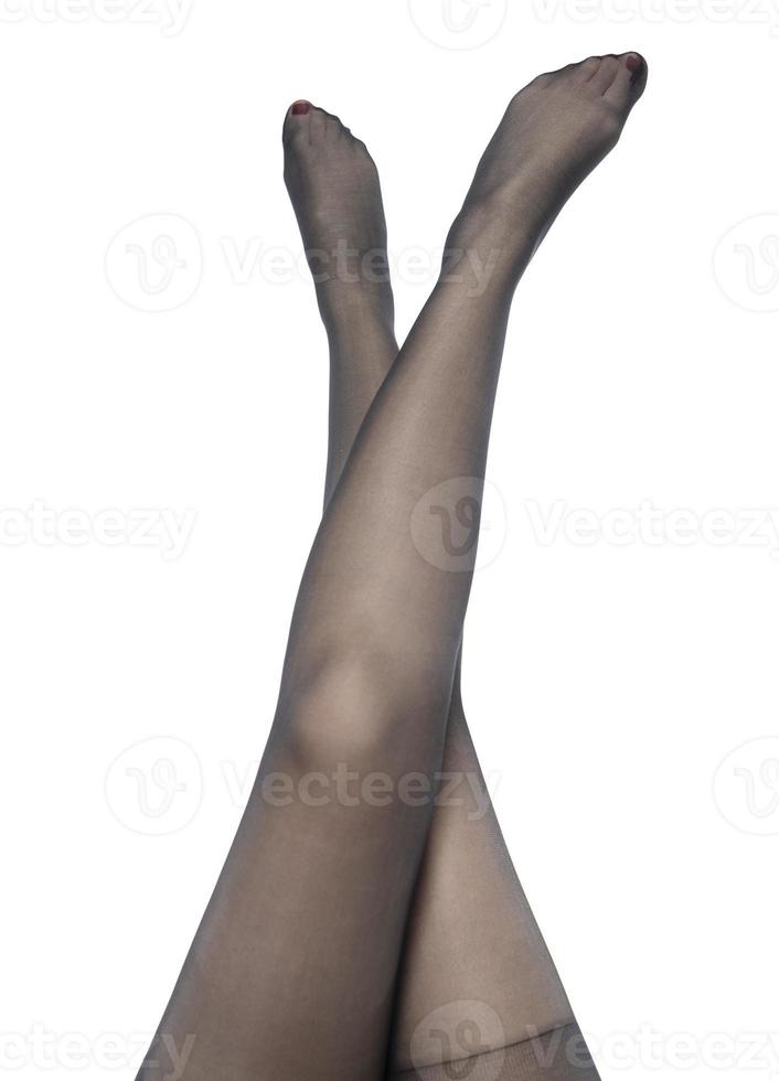 Woman puts on stockings on her beautiful long legs, isolated on white background photo