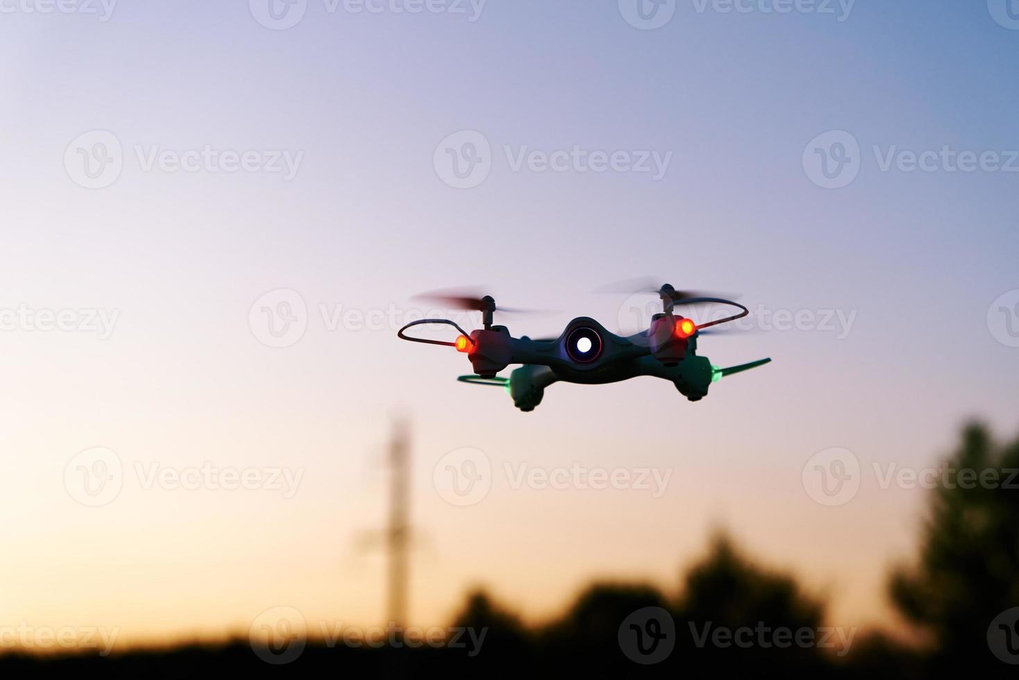helicóptero quad drone de juguete contra el cielo del atardecer foto