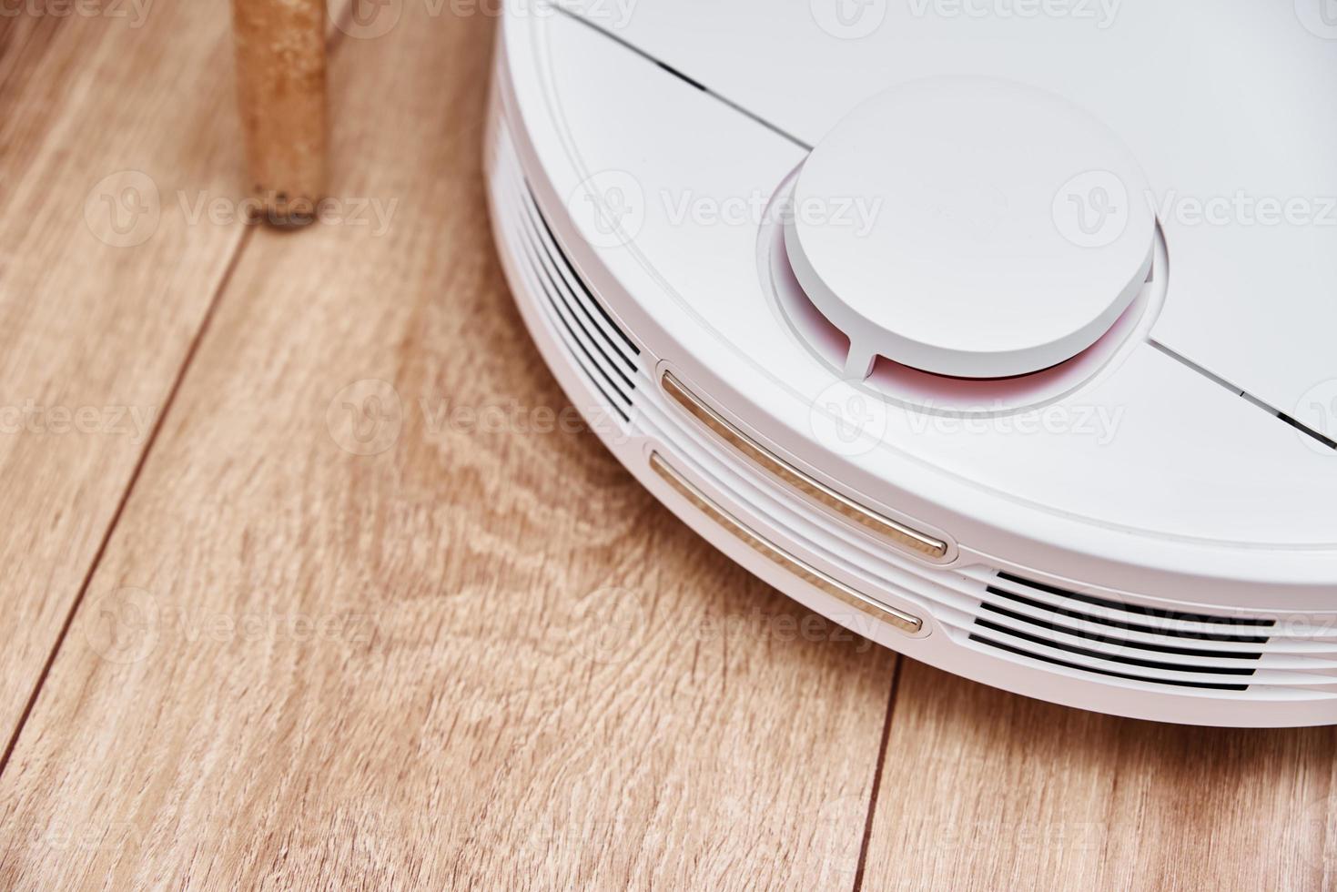 Robot vacuum cleaner working on the laminate floor. photo