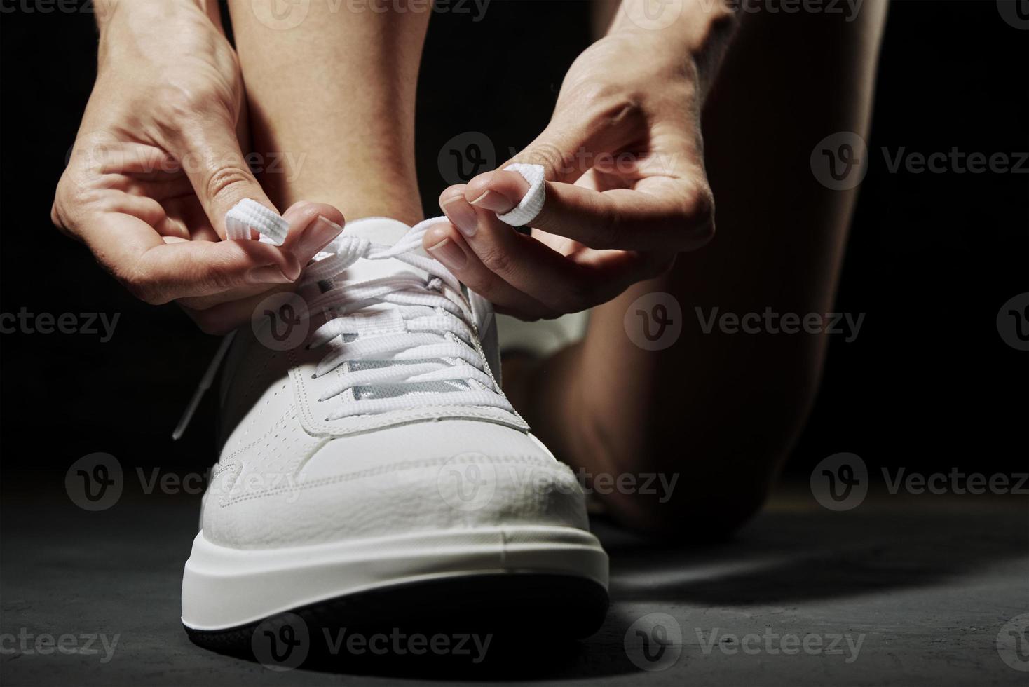 Woman hands tying shoelaces on sneakers photo